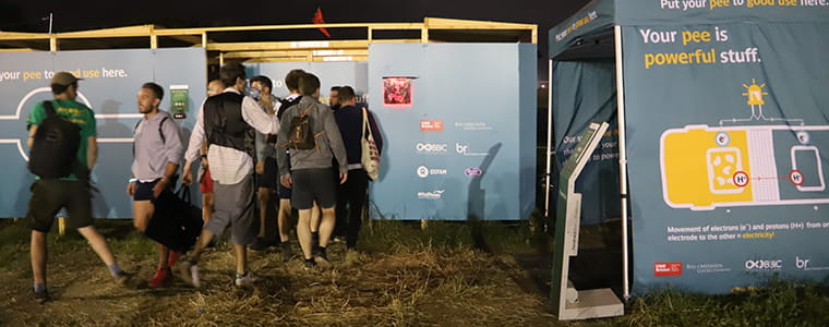 Queue of people waiting for pee power toilets at Glastonbury.