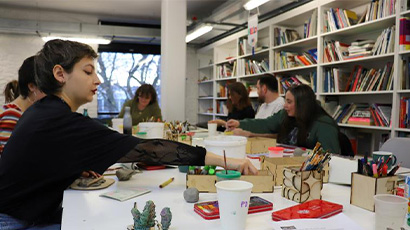 People sitting at a table participating in a creative workshop.