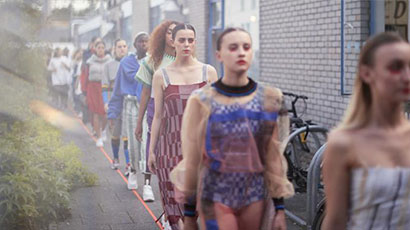 Models walking on catwalk outside of a building