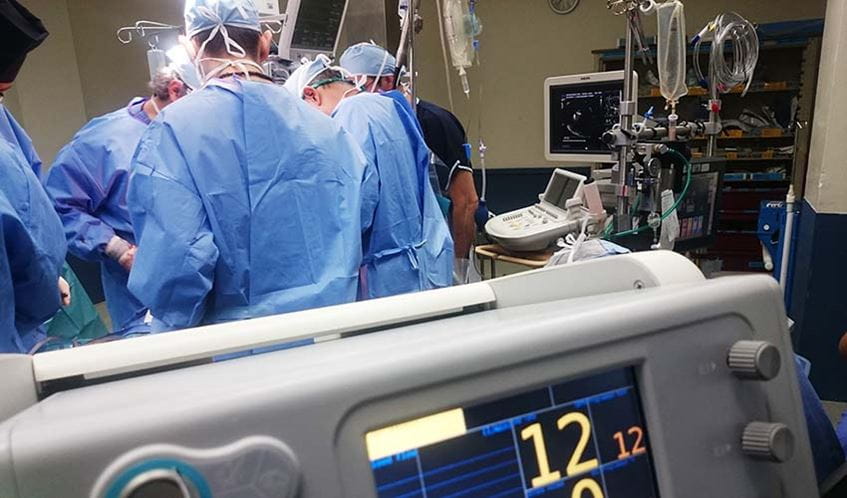 Doctors in a hospital operating theatre, carrying out surgery on a patient